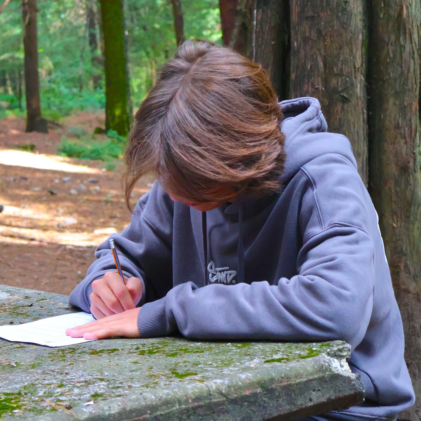Alumno reflexionando en el bosque